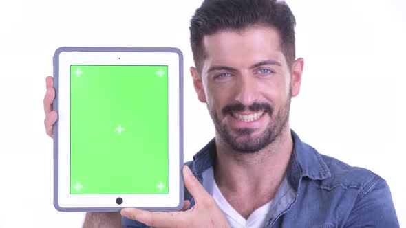 Face of Happy Young Bearded Hipster Man Showing Digital Tablet