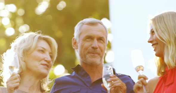 Friends interacting with each other while having champagne in balcony