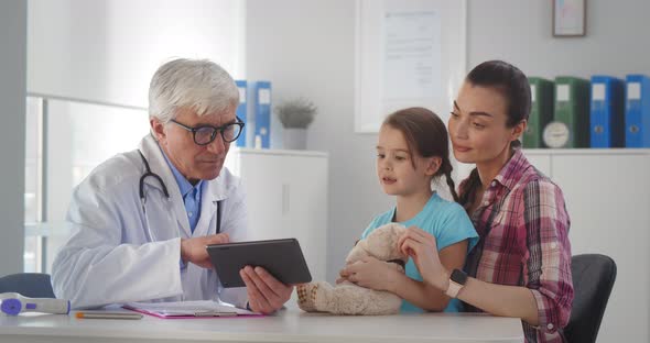 Mother and Daughter Visiting Pediatrician in Clinic Office