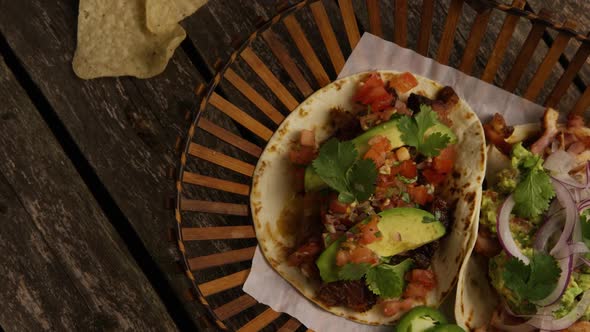 Rotating shot of delicious tacos on a wooden surface 