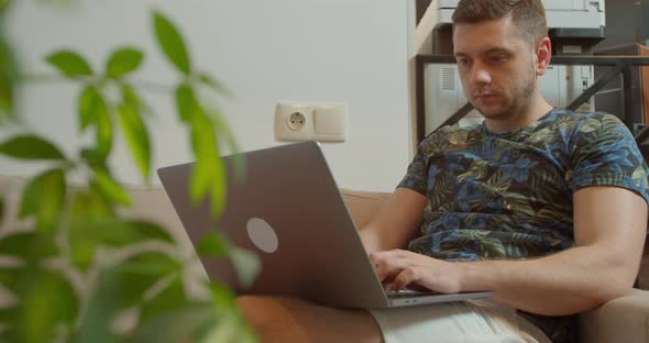 Young Man Using a Laptop To Send Work Emails, Shop Online To Navigate on Social Networks or e