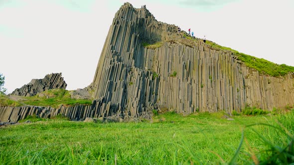 Hikers Descend a Columnar Basalt Rock