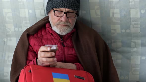 Portrait of a Sad Elderly Ukrainian Refugee Drinking Tea