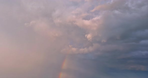 During a Severe Thunderstorm in a Landscape a Bright Rainbow Can Be Seen in the Sky