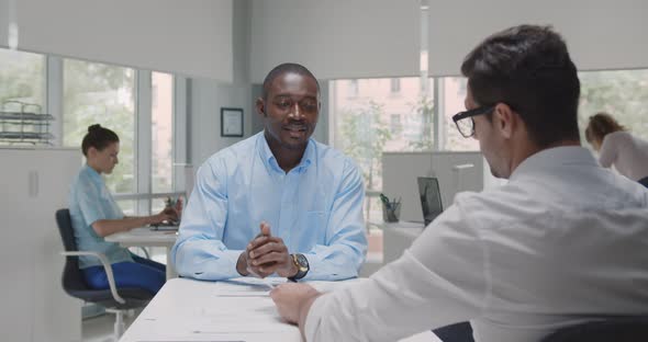 Back View of Hr Manager Interview African Male Candidate Sitting at Desk in Modern Office