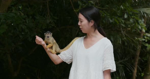 Woman feeding squirrel Monkey in park