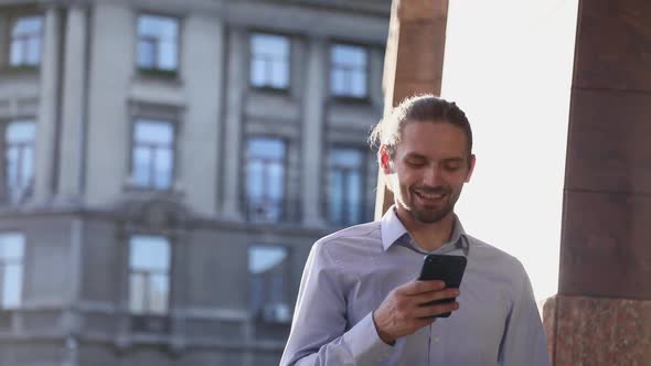 Business Man Using Mobile Phone On Street On Sunny Day