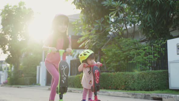 Development activity for children. Asian young girl kid playing small scooter riding on road outdoor