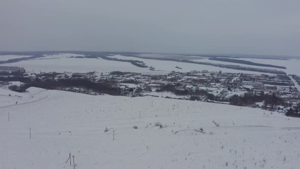 View of the Russian Village Through the Clouds in Winter at Dusk