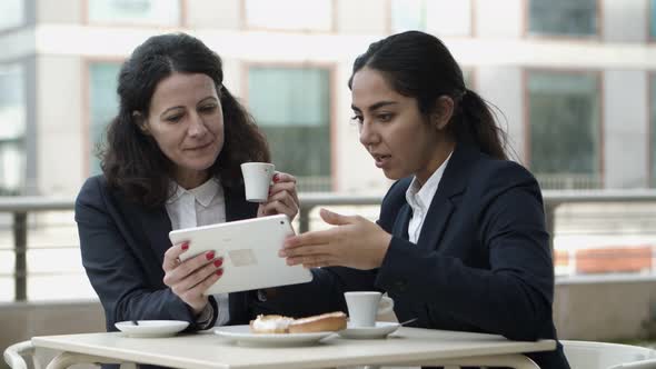 Smiling Businesswomen with Tablet Pc in Outdoor Cafe