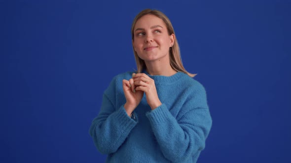 Pleased woman wearing blue sweater thinking about something