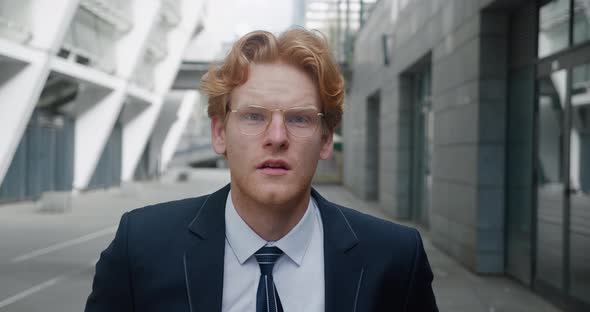 Shocked Young Redheaded Business Man in Classical Suit Looking at the Camera in Surprise