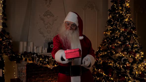 Smiling Santa Claus Gives Gift in Festive Red Box Christmas Winter Holidays