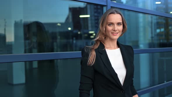 Portrait of Smiling Fashionable Lady Boss Posing at Modern Glass Building