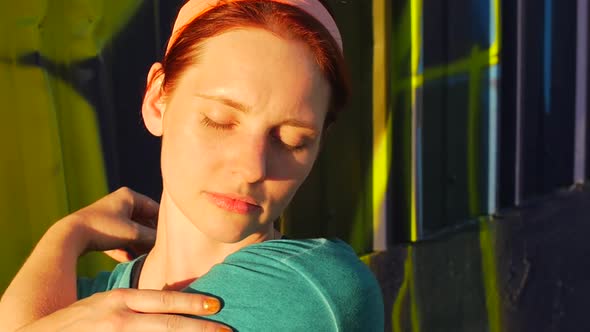 A young woman stretching before working out in urban environment.