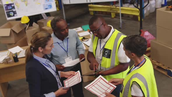 Warehouse staff with documents talking 4k