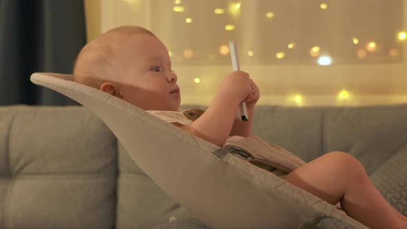 Cute Kid Holding Remote Control for TV Digital Media Player and Watching TV