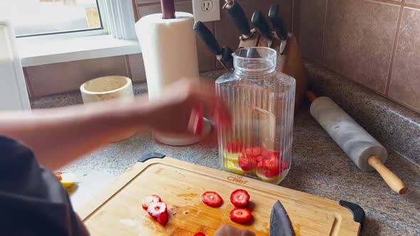 Healthy Lifestyle Habits, Woman Slices Fruits and Places into Glass Pitcher