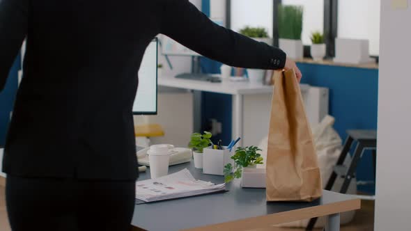 Cheerful Businesswoman Putting Food Takeaway Order Package on Desk Table During Lunchtime Break