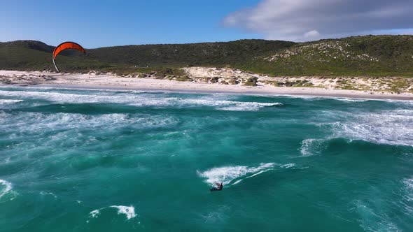 Slomo shot of daring kitesurfer launching off a wave and landing it; Cape Point