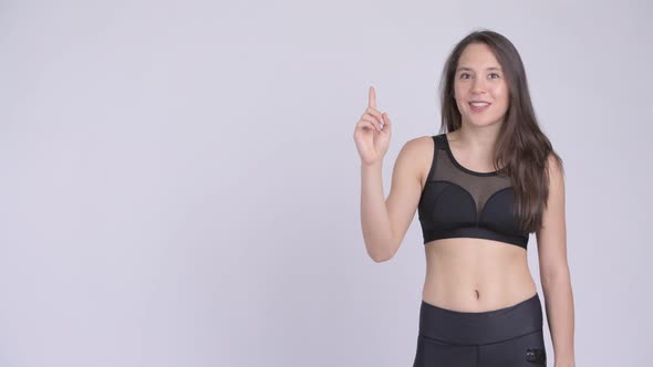 Young Happy Multi-ethnic Woman Pointing Up Ready for Gym