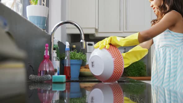 Girl washing utensils in the kitchen 