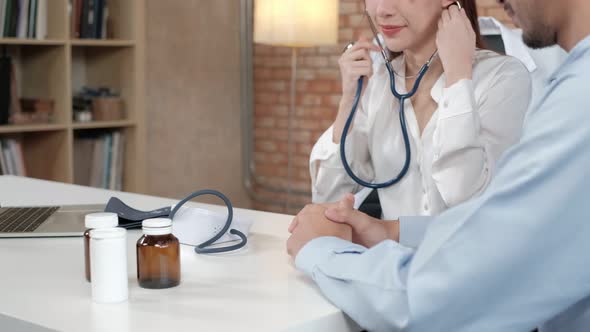 Young beautiful woman doctor is health examining a male patient.