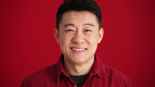 Smiling Asian man wearing shirt looking at the camera