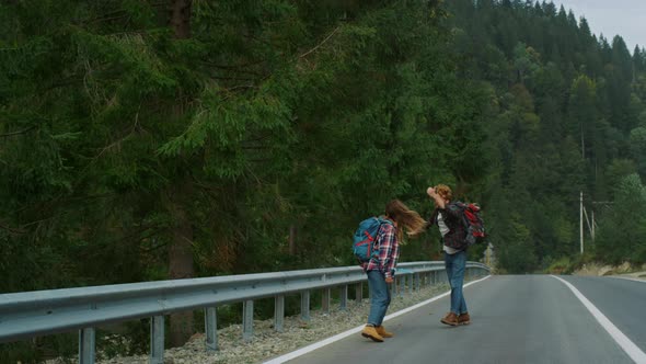 Dancing Lovers Walk Hitchhike on Forest Roadside