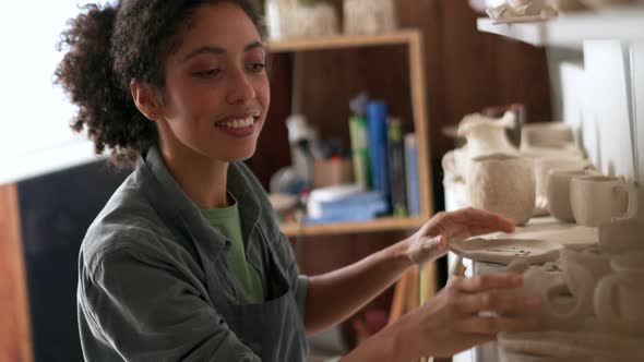 Woman potter choosing clay products