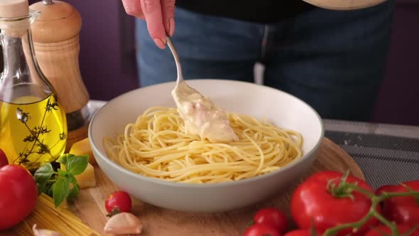 Making Pasta Carbonara  Adding Cream Sauce with Pancetta to Spaghetti in Ceramic Dish