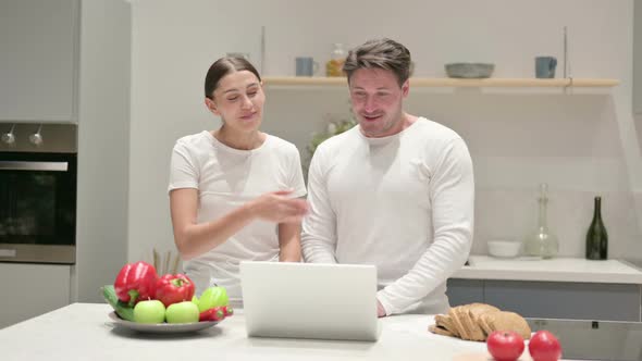 Mixed Race Couple Doing Video Call on Laptop in Kitchen