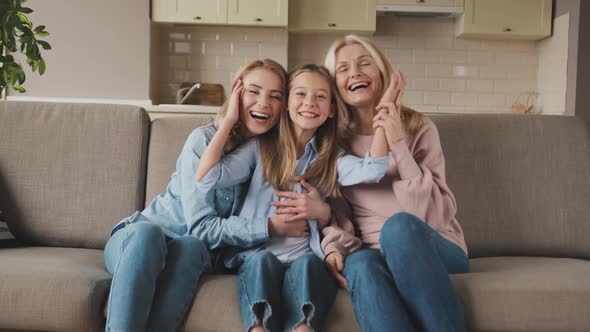 Three Generations of Women Look at Camera Cute Little Girl Hug Mom and Granny Enjoy Time at Home