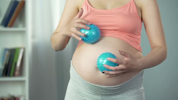 Woman Massaging Her Pregnant Belly With Rubber Balls to Relax and Relieve Stress