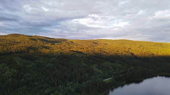 Soft sunlight spreading over the forest and valleys around Dease Lake in British Columbia, Canada. W