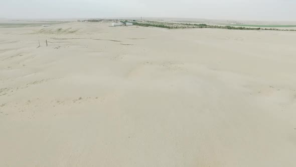 Flying Over Dunes Over Farming in the Desert and Showing Irrigation System for Farming