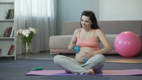 Woman Doing Massage to Her Tummy With Baby Inside With Little Fitness Balls