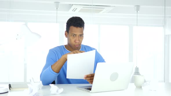 Afro-American Man Reading Documents in Office, Study