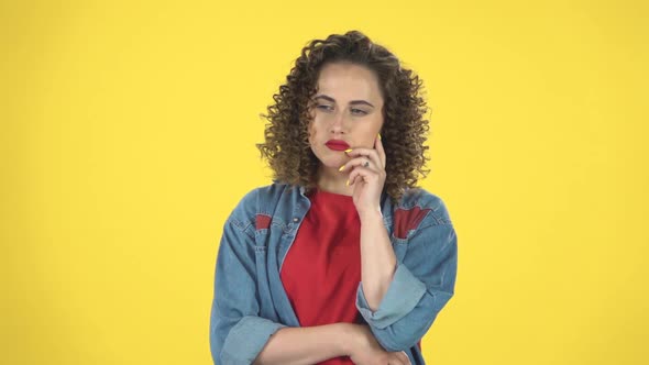 Girl Thinks and Listens, Looking Into the Camera with a Fork Forward, Shows the Index Finger