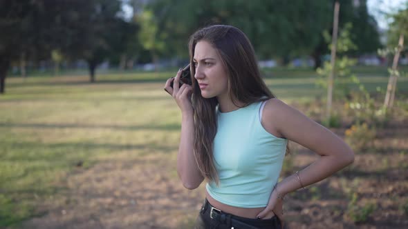 a Pretty White Girl Smiling and Listening to a Voice Message on Her Phone