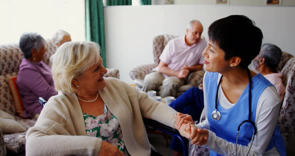 Front view of Asian female doctor interacting with senior woman at nursing home 4k