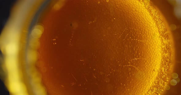 The Foam Is Dissolving on the Surface of the Beer Glass, View From the Bottom 