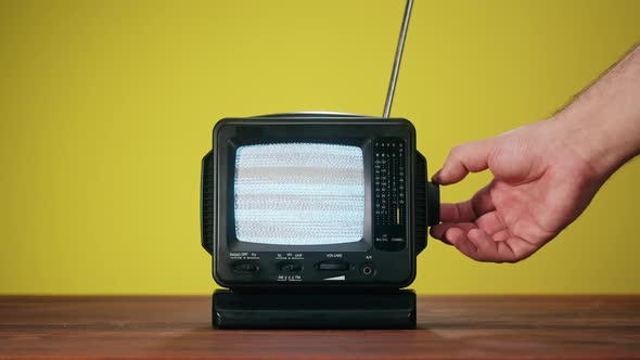 Small Old Television with Grey Interference Screen on Yellow Background