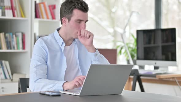Young Man Having Coughing Working on Laptop
