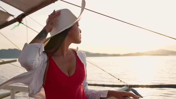 Woman Relaxing On Outrigger Boat In Sun Hat