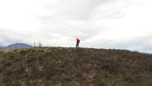 Man adventurer with backpack exploring Highlands in Scotland