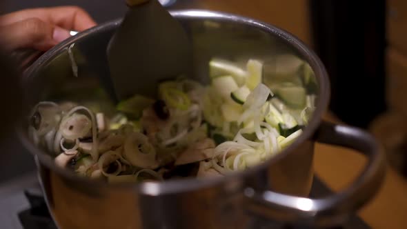 Sauteing zucchini courgette and mushrooms on a pan in slow motion