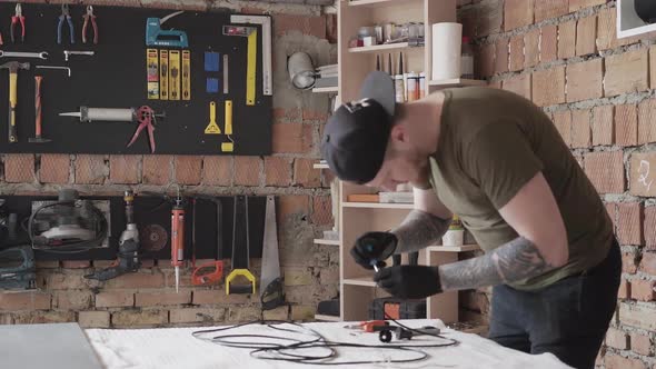 Carpenter in Cap Working with Electrical Wires. To Much Tools for Furniture Manufacture