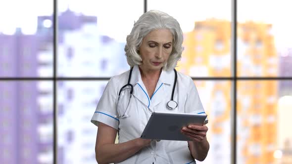 Troubled Senior Female Doctor with Tablet Pc