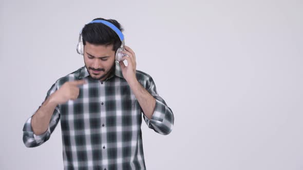 Portrait of Young Happy Bearded Indian Man Listening To Music